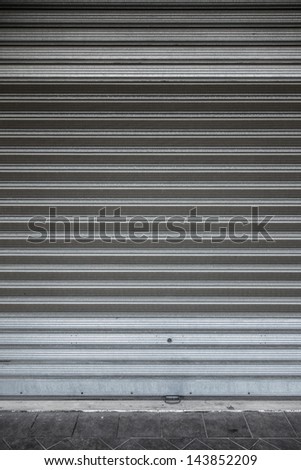 a shuttered roll up metal door with stains and scratches