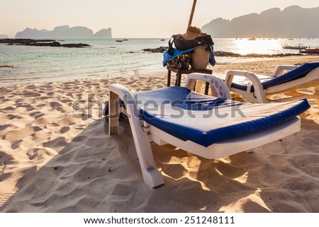 a plastic chaise lounge on a tropical beach on sunset in Phi Phi Island, Thailand