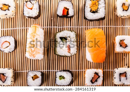 an assortment of different sushi pieces on a wooden bamboo sushi mat