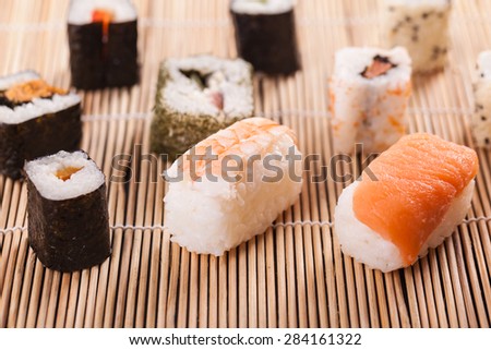 an assortment of different sushi pieces on a wooden bamboo sushi mat in a japanese restaurant