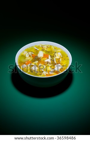 Spot of light on bowl of hot soup on green table