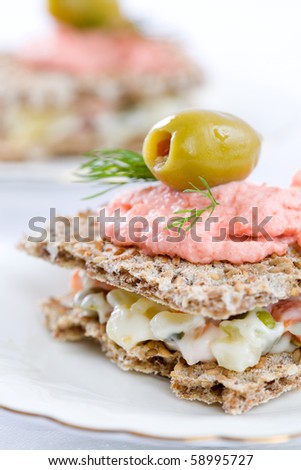 Small sandwiches for catering event on white plate and table cloth