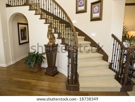 Mansion hallway with modern staircase and luxurious decor.