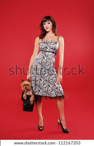 Elegant lady with cute little dog on the red background