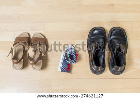 Three pair of shoes in father big, mother medium and son or daughter small kid size representing family, growth, education and togetherness concept
