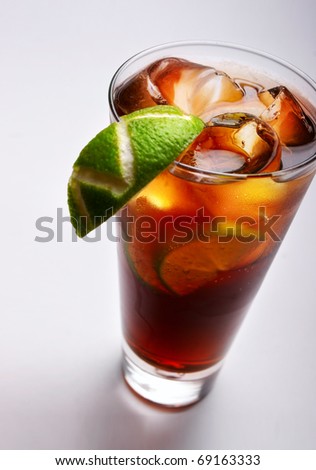 cold tea with lime and ice (close up) on gray background