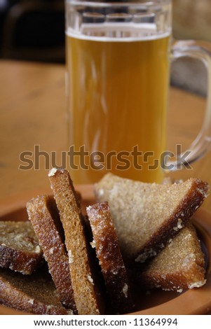 Rye-bread with garlic salt and beer on the wodden table