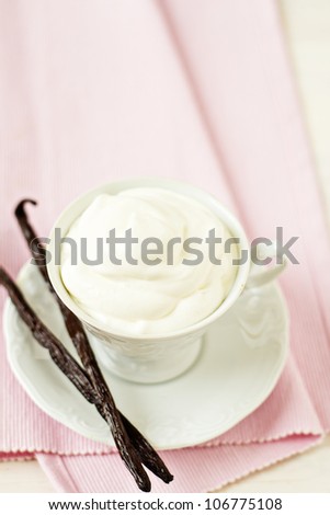 Cup filled with whipped cream with vanilla pods