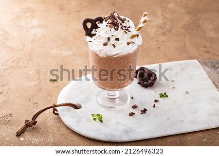 Iced chocolate coffee frappe topped with whipped cream and chocolate pretzels Photo stock © 