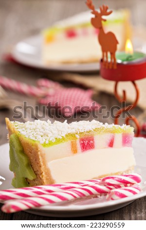 Cheesecake for christmas with colorful jelly on top, marzipan decoration and mint candies