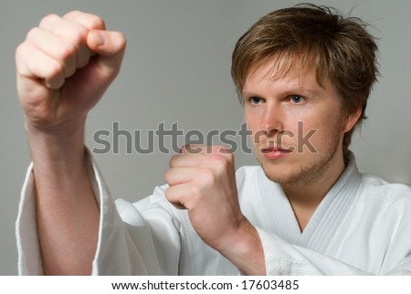 young adult with white kimono in karate fighting stance