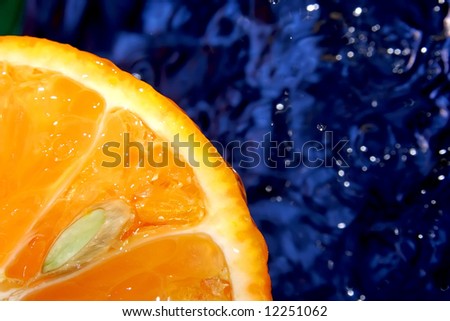 Fresh mandarin like rising sun. Pure water. Blue background.