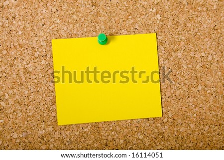 Yellow note paper pinned on a cork board
