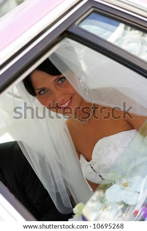 Bride smiling in wedding car limousine