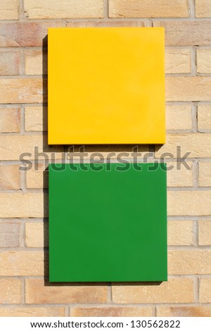 Black green and yellow signs on brick wall with copy space.