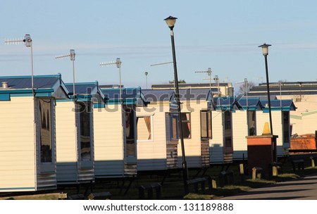 Row of caravans in trailer park at sunset.