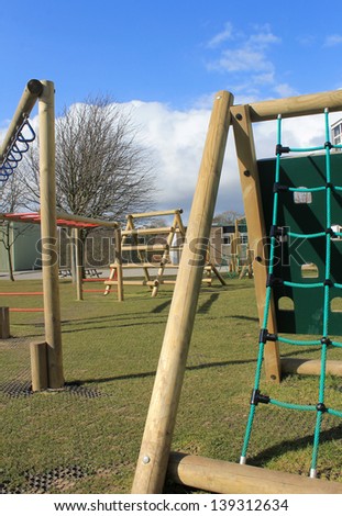 School climbing frame with playground and sports hall in background, Scarborough, England.