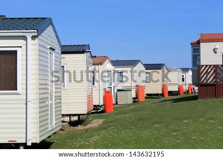 Row of caravans in trailer park, summer scene.
