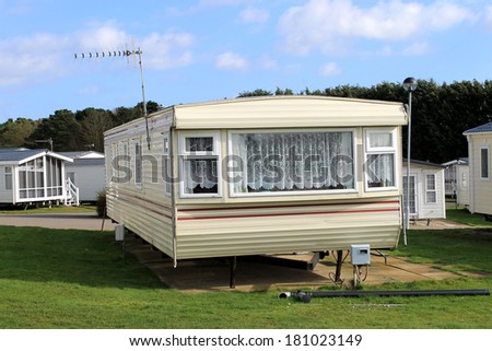 Scenic view of trailer on caravan park in summer with cloudscape background.