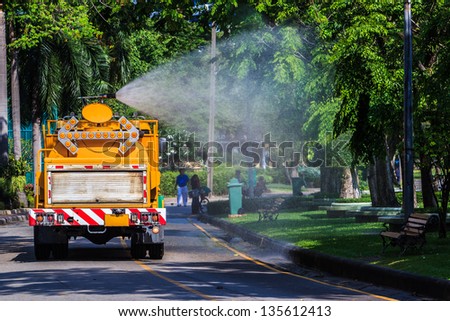 Watering in Public Park with Big Tank Sprayer showing Water mist Droplets