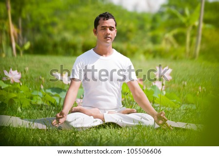 Young Man Sitting In Lotus Position Outside In Natural Environment ...