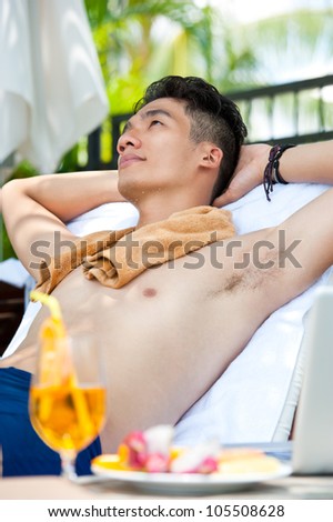 Young man sunbathing on the beach
