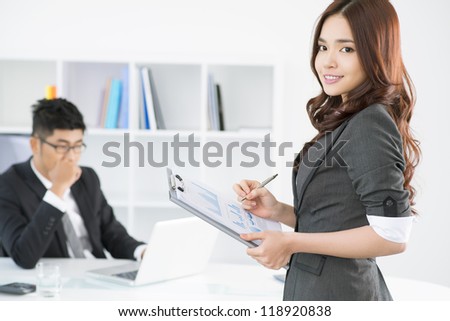 Lovely secretary bringing the annual report to her boss
