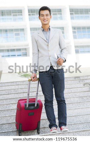 Portrait of young businessman with tickets and baggage going to airport