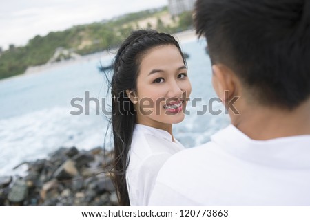 Young woman walking with her boyfriend and looking at camera