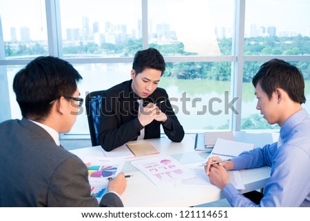 Three serious business people meeting to discuss the financial results of the year