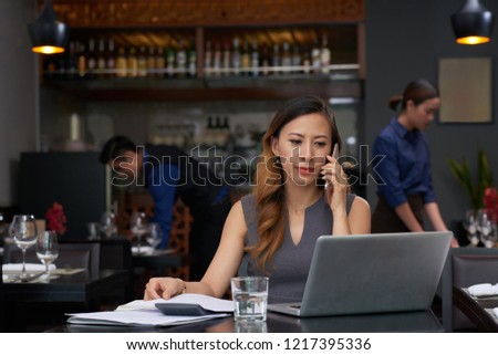 Smiling elegant business lady talking on phone and reading e-mails on laptop screen Stock foto © 