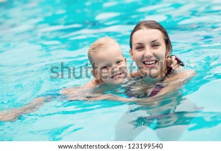 Adorable mom and kid keeping fit and healthy in water