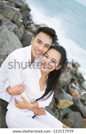 Vertical portrait of cuddling young holiday-makers being in love