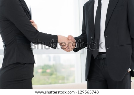 Closeup of co-workers\' handshaking