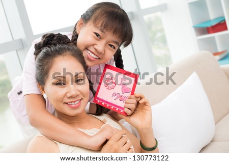 Close-up of embracing mum and daughter indoors