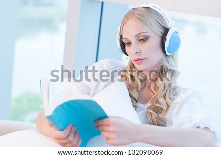 Woman listening to the music and reading a book