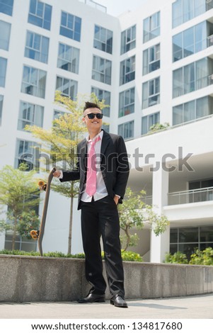 Modern businessman enjoying his after-work hobby of skating and listening to music