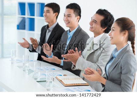 Businesspeople applauding at the end of the conference at the office