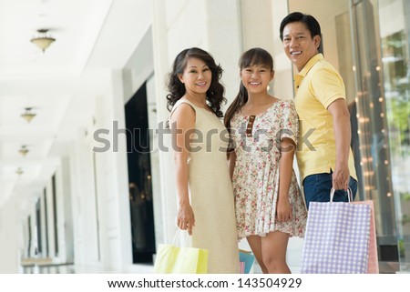 Copy-spaced portrait of a modern family with shopping-bags