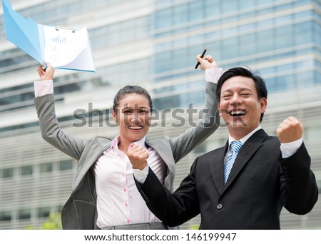 Portrait of excited co-workers showing fist at camera