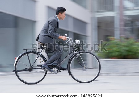 Profile image of an active businessman riding a bicycle on the way to job