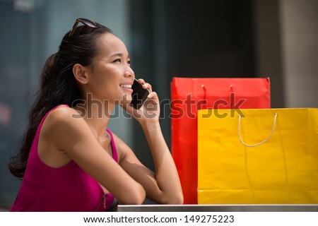 Lovely girl using a mobile phone in the shopping mall