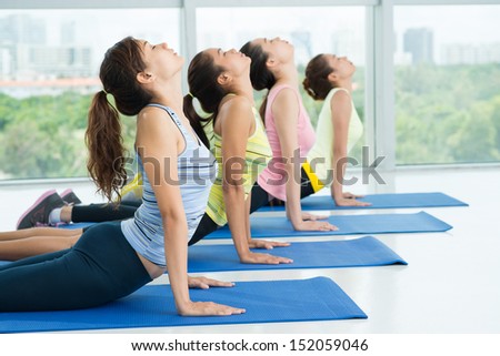 Women stretching their backs in a line