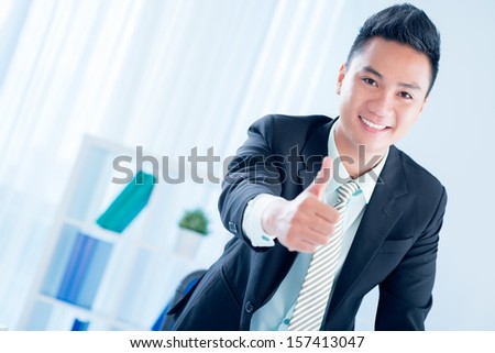 Copy-spaced portrait of a young financial consultant thumbing up on the foreground