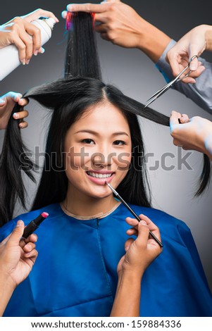 Vertical portrait of an attractive woman in the beauty salon isolated on grey