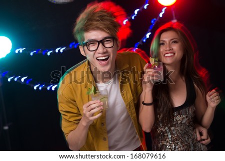 Close up portrait of a cheerful party couple having fun in the club
