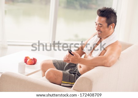 Fit athlete taking a break from workout to listen to the music