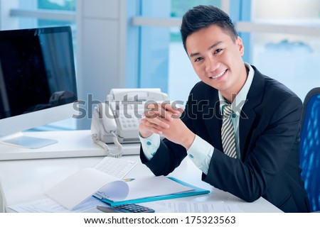 Close-up portrait of a young financial worker smiling and posing at camera