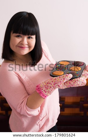 Copy-spaced portrait of a young pastry chef with delicious muffins posing at camera
