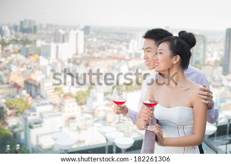 Copy-spaced image of a young couple seeing the sunrise with glasses of red wine